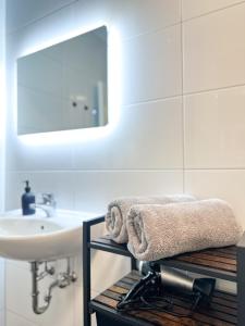 a bathroom with a sink and a mirror and towels at Elegantes City-Apartment im Herzen von Bad Mergentheim in Bad Mergentheim
