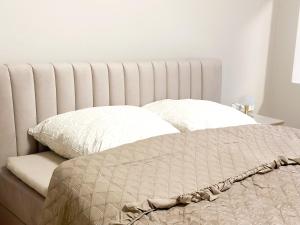 a bed with white sheets and pillows on it at Elegantes City-Apartment im Herzen von Bad Mergentheim in Bad Mergentheim