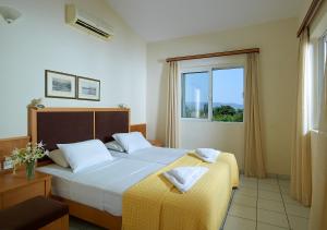 a bedroom with a large bed and a window at Mousses Apartments & Studios in Kissamos