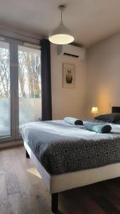a bedroom with a bed and a large window at Le Brienne Toulouse Centre in Toulouse