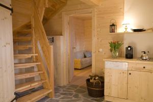 eine Blockhausküche mit Treppe und Sofa in der Unterkunft Brandluckner Nesterl in Heilbrunn
