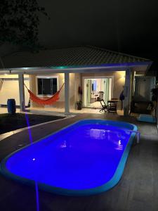 a blue pool in front of a house at night at Res Praia e Sol litoral do Pr Matinhos in Matinhos