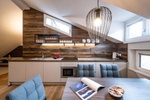 a kitchen with a dining table and blue chairs at Odilia - Historic City Apartments - center of Brixen in Bressanone