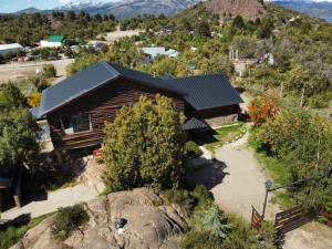 an aerial view of a log house with a mountain at Hostel Andino in Villa Pehuenia