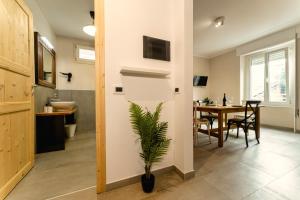 una cucina e una sala da pranzo con tavolo e pianta di Residence La Corte - Bilocale 6 a Novara