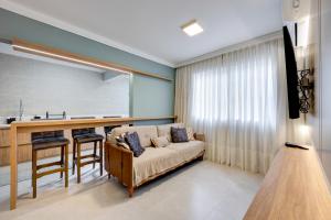 un salon avec un canapé et une cuisine dans l'établissement Luxo com Vista mar lateral em todos os cômodos, à Balneário Camboriú