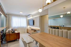 une cuisine et une salle à manger avec une table et des chaises dans l'établissement Luxo com Vista mar lateral em todos os cômodos, à Balneário Camboriú