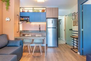 eine kleine Küche mit Kühlschrank und Couch in der Unterkunft Nannai Residence Muro Alto Porto de Galinhas Beira Mar in Porto De Galinhas