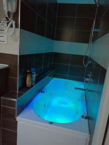 a blue tub in a bathroom with black tiles at Voyage Deluxe Master Room in La Spezia