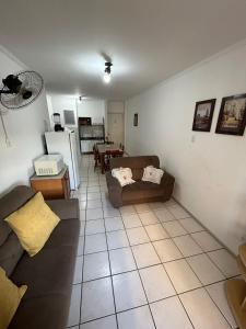 una sala de estar con un sofá y una mesa en Apartamento 3 quartos - 2 Quadras da Prainha - Torres RS, en Torres