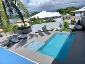 an overhead view of a swimming pool with chaise lounge chairs and a swimming pool at Kasa Créole in Les Trois-Îlets