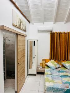a bedroom with a bed and a window and a door at Bungalow cosy Mon petit Diamant avec piscine privé in Le Diamant