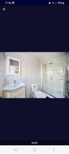 Un baño con inodoro, lavabo y ducha. en Room close to Heathrow All terminal, en New Bedfont