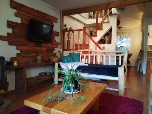 a bedroom with a bed and a tv on a wall at Casa Rústica Sureña Grande in Valdivia