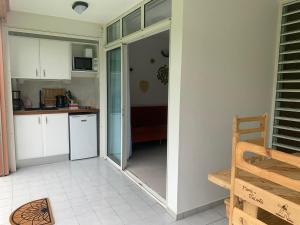una cucina con armadi bianchi e una porta che conduce in una camera di Studio Limyè a Folle Anse Altre 14 foto