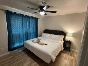 a bedroom with a white bed with a ceiling fan at Comfort Home WiFi n Hottub in Midwest City +29 photos