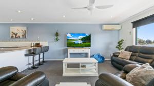 a living room with leather furniture and a bar at Lakes In Town - Central Getaway in Lakes Entrance
