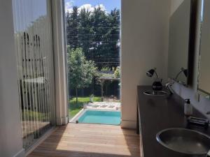 a bathroom with a door open to a swimming pool at PILAR BARRIO PRIVADO con AMENITIES CASA 6 AMB CON PISCINA in Manuel Alberti