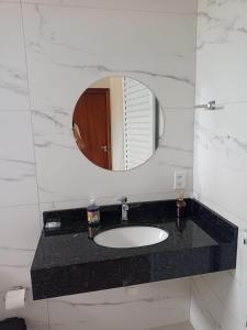 a bathroom with a sink and a mirror at Sobrado com garagem in Sorriso +7 photos