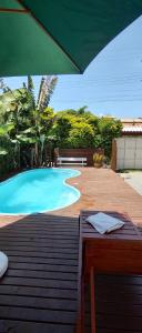 a swimming pool with a table and an umbrella at Cabana ferrugem pool in Garopaba