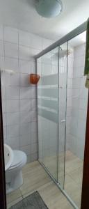 a bathroom with a glass shower with a toilet at Cabana ferrugem pool in Garopaba