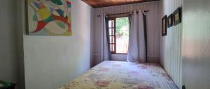a bedroom with a bed in a room with a window at Cabana ferrugem pool in Garopaba