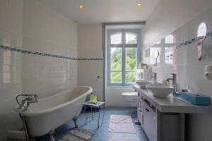 a bathroom with a tub and two sinks and a toilet at Villa de charme, 15 personnes, vue canal in Rohan +42 photos