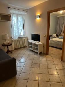 a living room with a couch and a television and a bed at Locanda Delle Fate in San Giovanni in Marignano