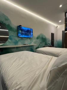 诗巫THE SWAN hotel的一间卧室，有两张床和一台挂在墙上的电视