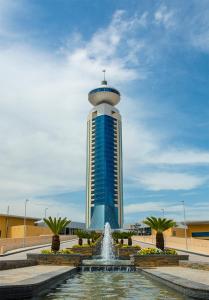 una torre con una fontana di fronte a un edificio di Grand Millennium Sulaimani a As Sulaymānīyah