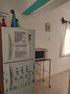 a refrigerator with a sign on it next to a microwave at Departamento Acapulco tres mares in Acapulco