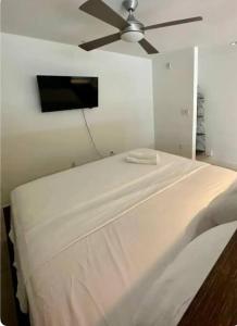 a white bed in a room with a ceiling fan at Luxury Penthouse Loft w POOL GYM AMERICANA in Glendale +18 photos