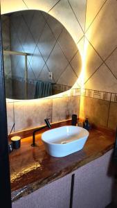 un bagno con un lavandino e un grande specchio di A Jóia do Cassino a Rio Grande
