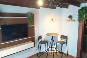 una cucina con tavolo, due sedie e una TV di A Jóia do Cassino a Rio Grande