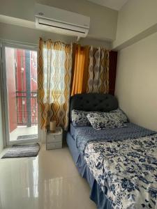 Lapu Lapu CityにあるAaliyah's Staycation in Lapu-Lapu Cebuのベッドと窓のある小さな寝室