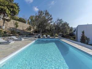 a large swimming pool with blue water in a yard at Traditional villa with swimming pool in Ano Mera
