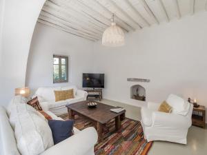 a living room with white furniture and a table at Traditional villa with swimming pool in Ano Mera