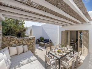 a patio with a couch and a table and chairs at Traditional villa with swimming pool in Ano Mera