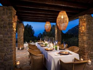 a long table with chairs and lights on a patio at Traditional villa with private pool in Banyalbufar