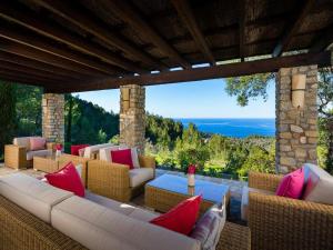 a patio with wicker furniture and a view of the ocean at Traditional villa with private pool in Banyalbufar