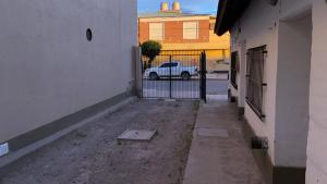 センテナリオにあるDepartamentos El Amanecerの門と白いトラックが建つ路地