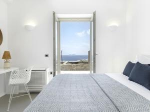 a bedroom with a bed and a desk and a window at Pristine villa with swimming pool in Kalafatis +32 photos