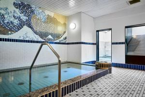 a swimming pool in a building with a large painting on the wall at Hotel Sobial Osaka Dome in Osaka +81 photos