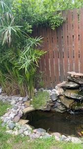 a garden with a pond in front of a fence at Rocío de Luz in San Clemente del Tuyú