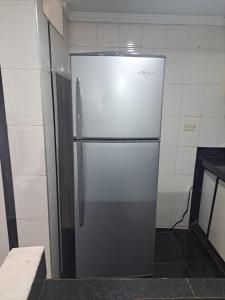 a stainless steel refrigerator in a small kitchen at Hospedaje la Estrella in Floridablanca
