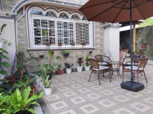 a patio with a table and chairs and an umbrella at Topaz Bed & Breakfast Hotel in San Jose