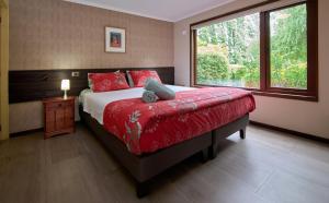 Un dormitorio con una cama con almohadas rojas y una ventana. en Mirabosque New Apartments 3, en Osorno 15 fotos más