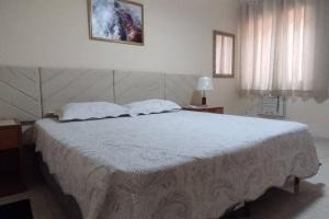 une chambre avec un grand lit avec des draps blancs dans l'établissement Apartamento ACOLHEDOR, à Rio de Janeiro