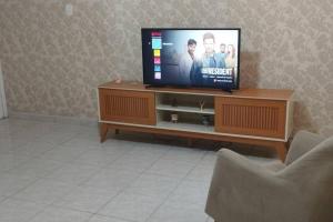 - une télévision à écran plat installée sur un centre de divertissement en bois dans l'établissement Apartamento ACOLHEDOR, à Rio de Janeiro