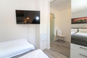a bedroom with a bed and a tv on the wall at Rote-Muehle in Greetsiel